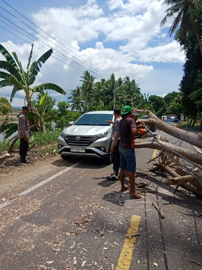 
					Gerak Cepat Anggota Polsek Ujung Loe, Tangani Kemacetan Akibat Pohon Tumbang.